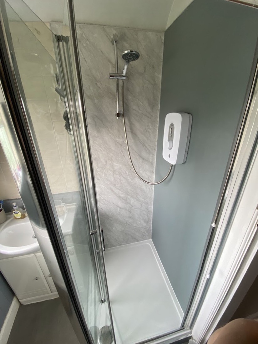 Compact shower enclosure with marble-effect wall panels